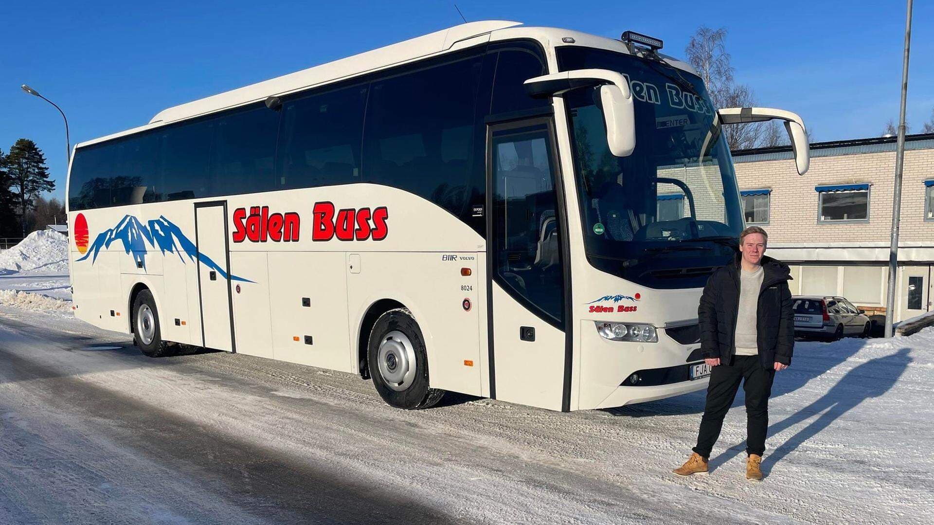 Robin Andersson står framför en buss.