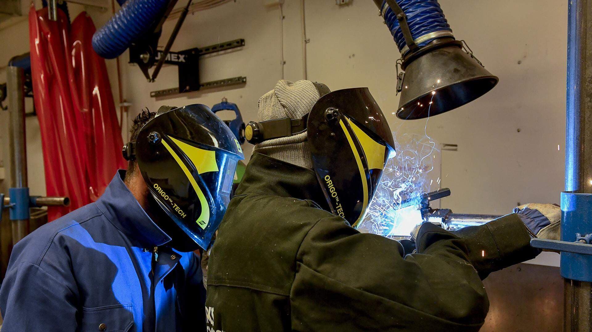 Två personer som svetsar