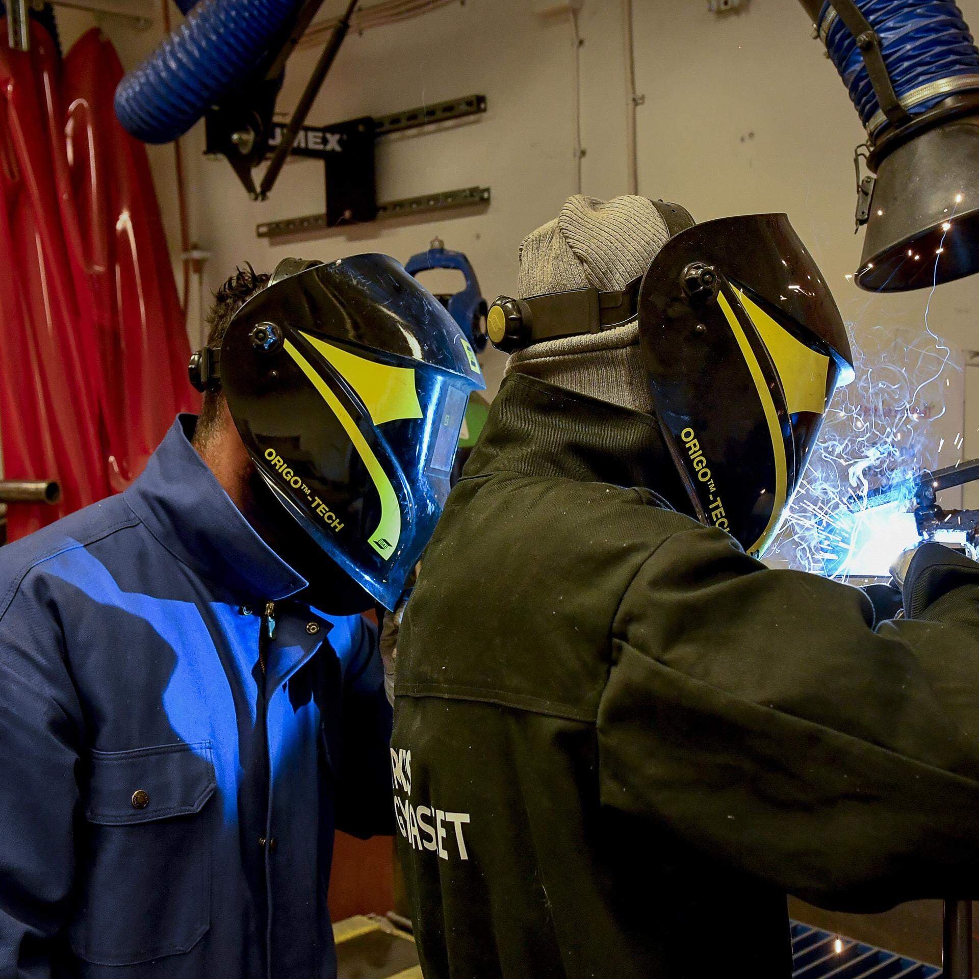 Två personer som svetsar