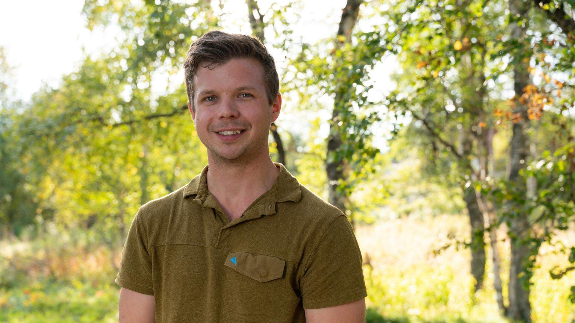 Gustaf Sjödin står utomhus på sommaren