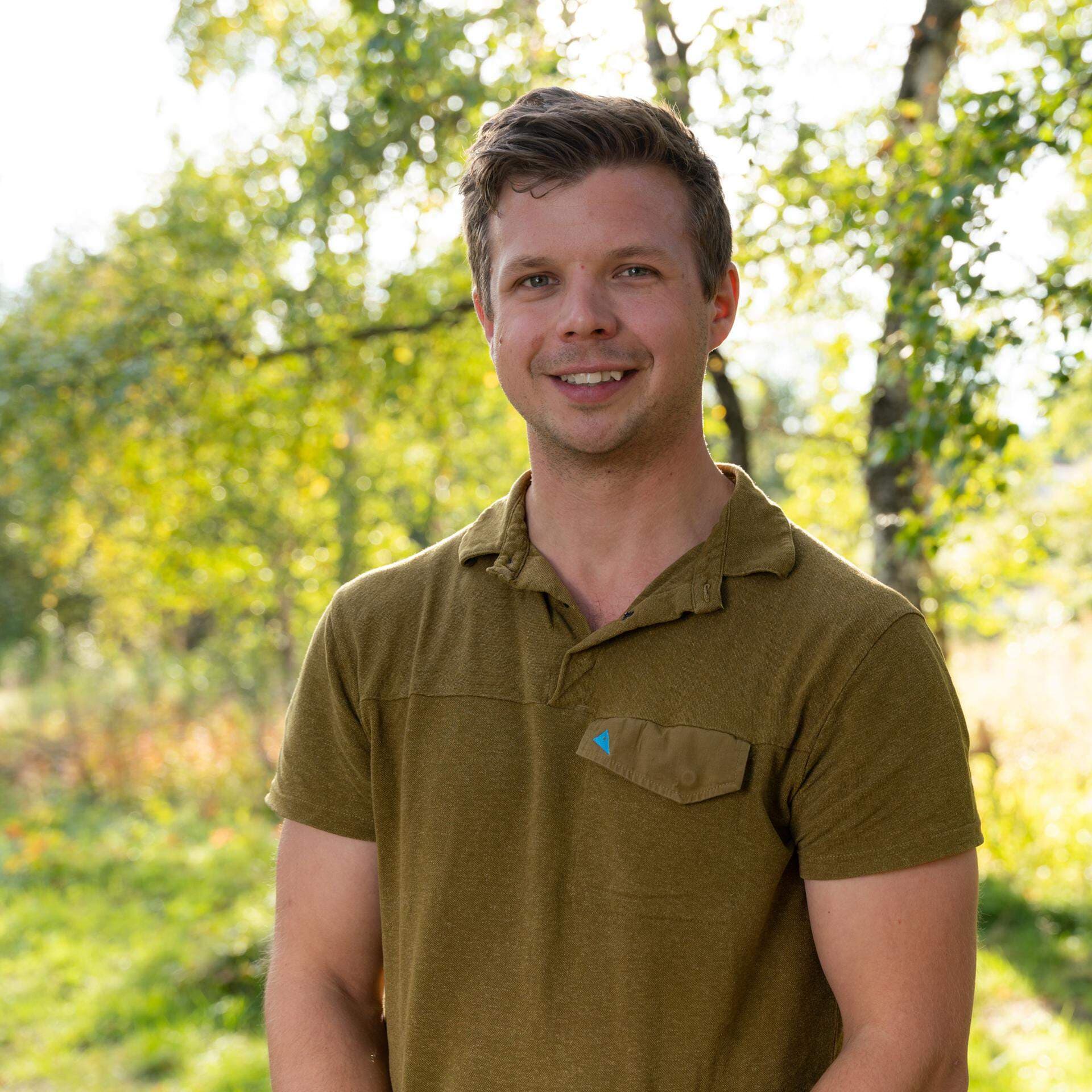 Gustaf Sjödin står utomhus på sommaren