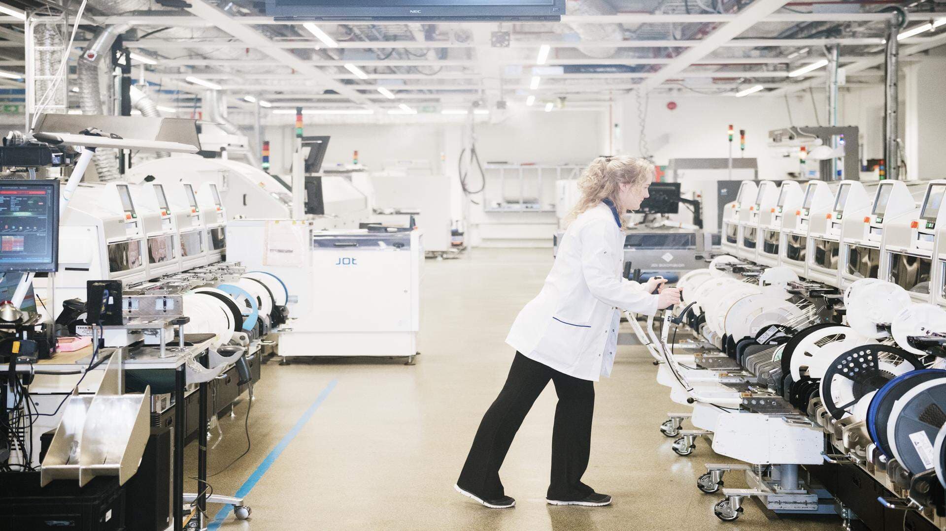 Ingenjörer i vita rockar som arbetar i ett lab